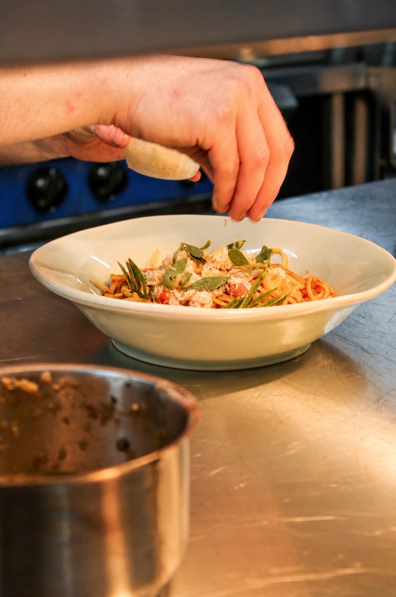 Hands garnishing a dish in the Latimers kitchen